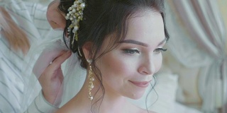 婚礼前，发型师给新娘戴上面纱