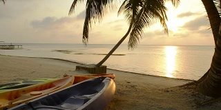 日出时沙滩上的皮划艇