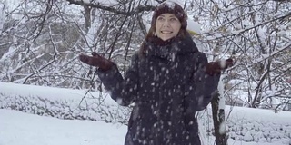 年轻女子在户外享受冬日。雪的冬天的梦想。慢动作