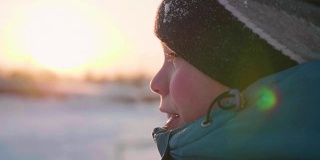 一个少年在冬日公园的笑脸特写。日落的时间。在户外散步。健康的生活方式