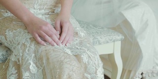 穿着婚纱的年轻新娘剪裁身体坐在化妆师作为作品。