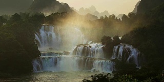 日出鸟瞰越南的Bangioc瀑布和中国的Detian瀑布，位于边境附近，人们可以看到这两个国家的瀑布。
