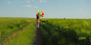 小女孩在田野里拿着气球