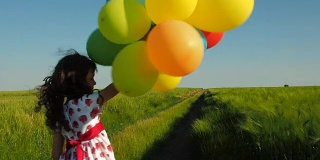 小女孩在田野里拿着气球