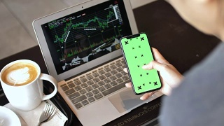 用电脑和智能手机分析股票的女商人视频素材模板下载