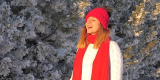 穿着毛衣的女人在冬天的大街上看着日落，嘴里吐出蒸汽