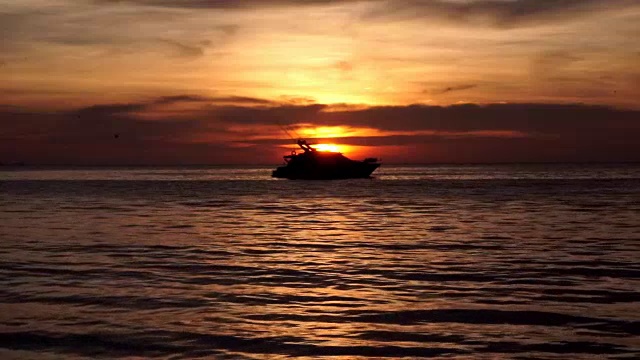 平静海面上的豪华船在日落时的剪影
