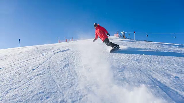 滑雪者从滑雪坡上冲下来，雪花向他喷来