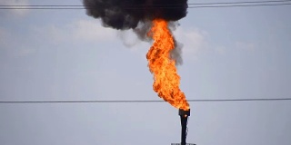 冒烟的气体火炬。环境污染。油田上的火炬系统