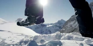 慢镜头拍摄的人走在雪山环境在阳光明媚的一天