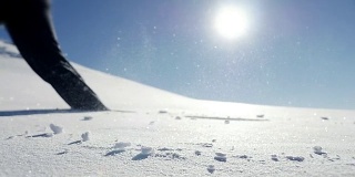 慢镜头拍摄的人走在雪山环境在阳光明媚的一天