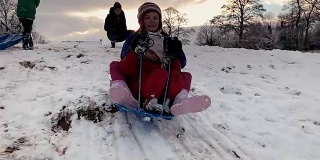 圣诞假期，姐妹们在雪山上共用一辆雪橇