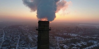 空中特写拍摄的一个巨大的工业塔与白色烟雾在日落在冬天