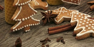 圣诞节自制的姜饼曲奇放在木桌上。由天然蜂蜡制成的黄色香味蜡烛。