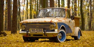 复古的莫斯科车与木制定制行李箱在秋天的森林