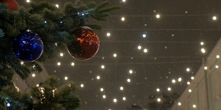 新年球挂在圣诞树上，彩色的灯。红球，街树，白雪覆盖。