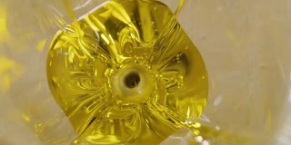 两颗橄榄落入玻璃杯里的橄榄油中