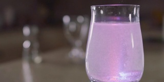 泡腾片溶于玻璃与水和闪闪发光的彩色灯光
