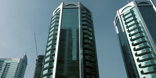 在阿联酋沙迦城摩天大楼的玻璃幕墙上，在天空背景下的视图