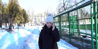 快乐的女孩在电话里聊着城市雪冬天。Slowmotion 120帧/秒