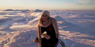 女孩徒步旅行在雪上的斯洛伐克山脉在冬季日落云层之上的慢动作