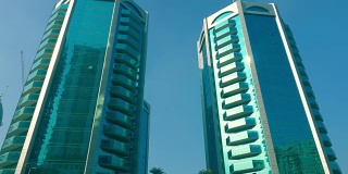 阳光照在摩天大楼的窗玻璃上。在沙迦现代城市的现代摩天大楼的玻璃幕墙反射阳光