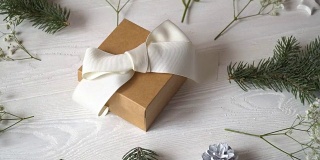 牛皮纸礼物与白色蝴蝶结和鲜花贺卡为情人节或婚礼在乡村风格与地方为你的文字，平躺，俯视图