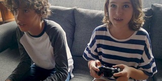 11 -12岁的小男孩和小女孩用手持控制器玩电子游戏