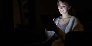 女人在平板电脑上的夜间在线视频聊天