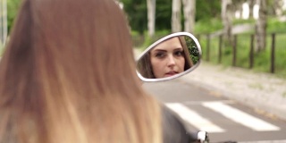 女孩在摩托车镜子里的倒影。