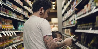 亚洲男子在超市用智能手机买食物。