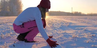 女人在夕阳下赏雪抛雪站在雪下