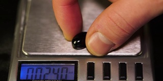药剂师，用对照天平称一下药片的重量。体重秤上的减肥药。减肥药溢出