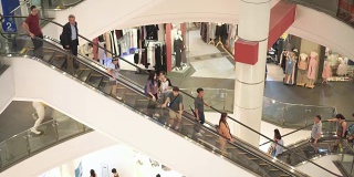 商场里拥挤的人在自动扶梯上移动