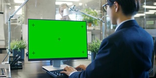 在办公室里，商人在他的办公桌上用一台模拟的绿色屏幕的个人电脑工作。同事走进办公室，并在她的办公桌前发生。