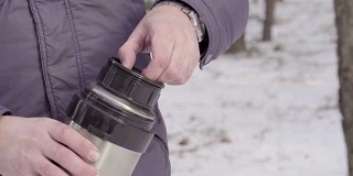 在冬季森林里，男人关上了保温瓶4K