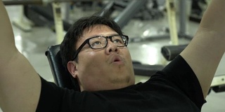 平移镜头的胖亚洲人做胸部锻炼