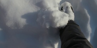 俯视着走过厚厚的雪地的双脚
