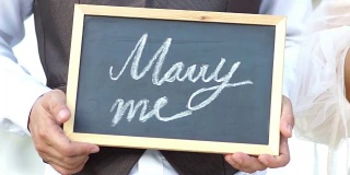 结婚的概念。你愿意嫁给我吗?年轻人在黑板上写下的问题。
