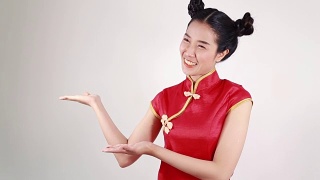 妇女穿着红色旗袍，用手势表示祝贺，寓意春节快乐视频素材模板下载