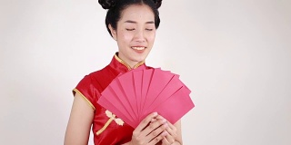 女人穿着旗袍，拿着红包，寓意春节快乐