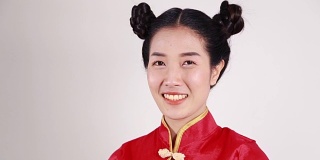 微笑的女人穿着红色旗袍，寓意春节快乐
