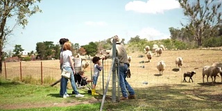 农场工人向一家人展示他的羊