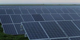 太阳电池板拍摄日出与多云的天空在法国诺曼底。现代电力生产技术。环保电力生产