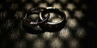 牛皮纸盒子上的两个结婚戒指。黑暗的场景