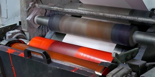 在工厂的装配线上，墨辊旋转，给信封带来颜色