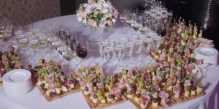 Furshet。桌上满杯起泡白葡萄酒与小点心和开胃菜的背景。香槟的泡沫