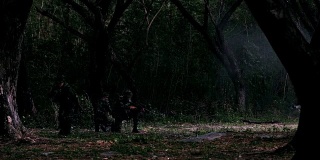 剪影，一队全副武装的士兵在森林中排成单行