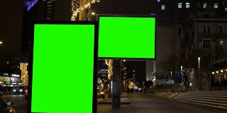 两块带有绿色屏幕的广告牌。