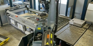 金属工厂的机器手臂捡起金属板
